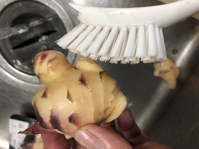 生姜の隙間をブラシで洗う写真